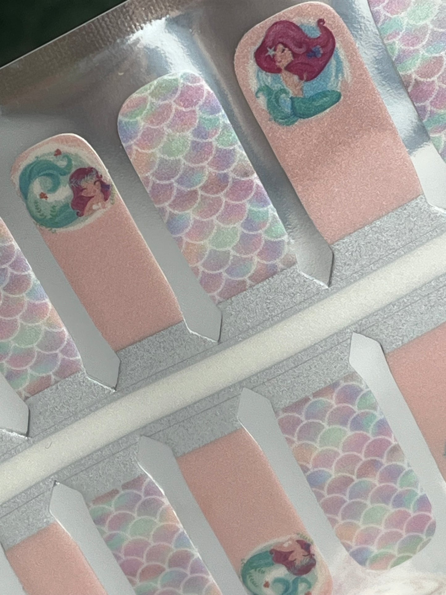 Pink Disney Little Mermaid Ariel nail strips featuring iridescent mermaid scales and character designs.